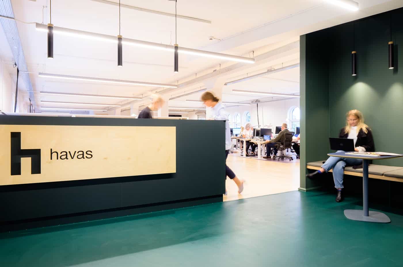 Business meeting at Havas office with professionals seated around a modern conference table in a well-lit workspace.