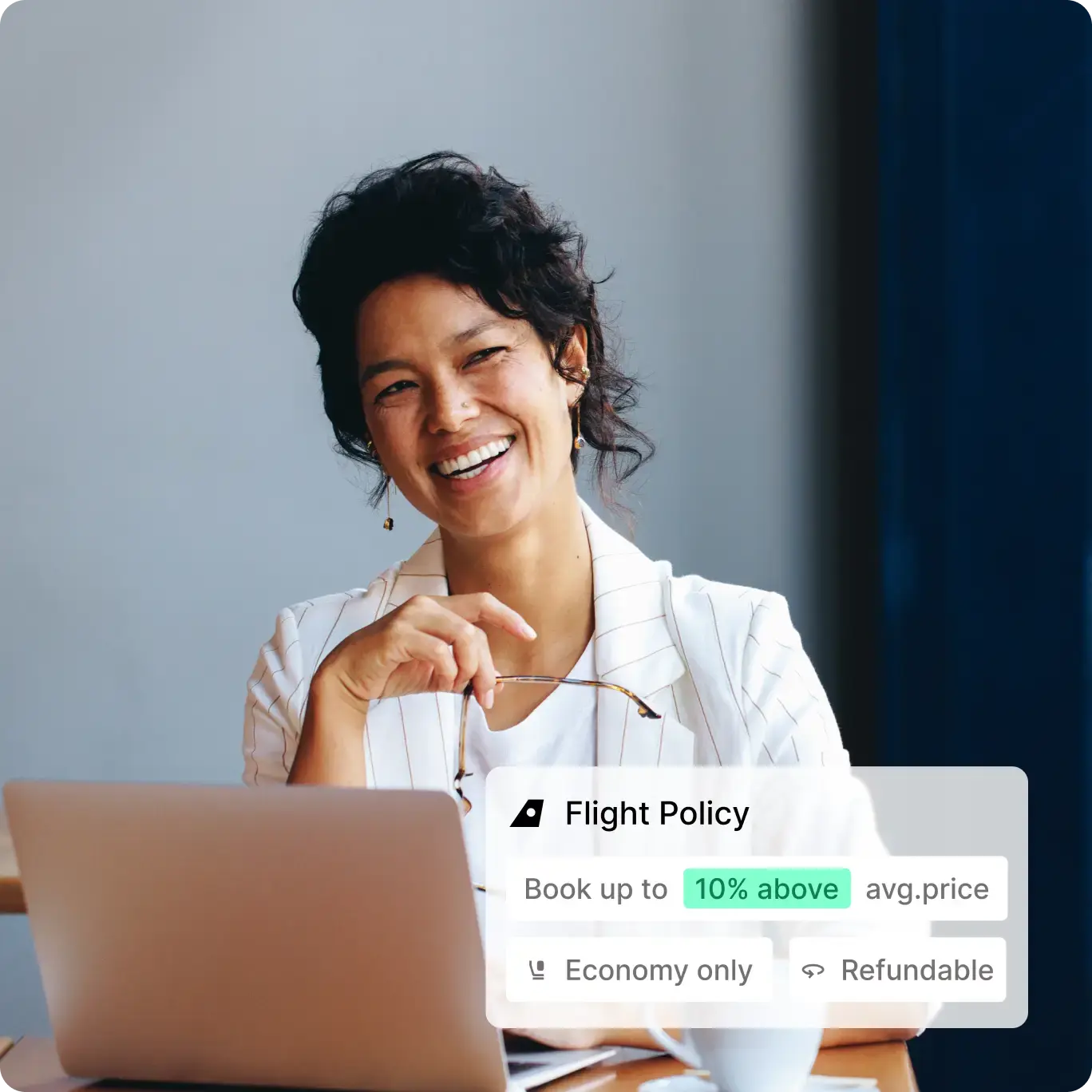 Smiling finance professional using a travel management system and box showing goodwings travel policy tools in action
